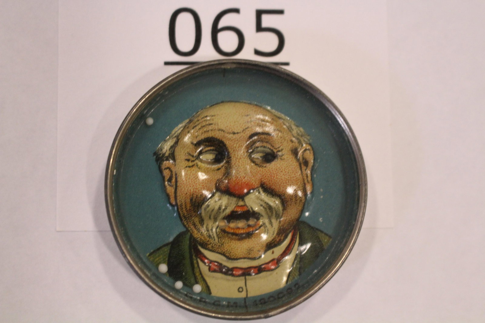 Cigar Advertising Dexterity Game Elderly Gentleman: Cigar advertising dexterity game / handheld puzzle game embossed image of an elderly man with moving eyes, goal is his teeth, D.R.G.M. No. 180082, metal rim, cardboard back "The Very Best A & L 5 Cent