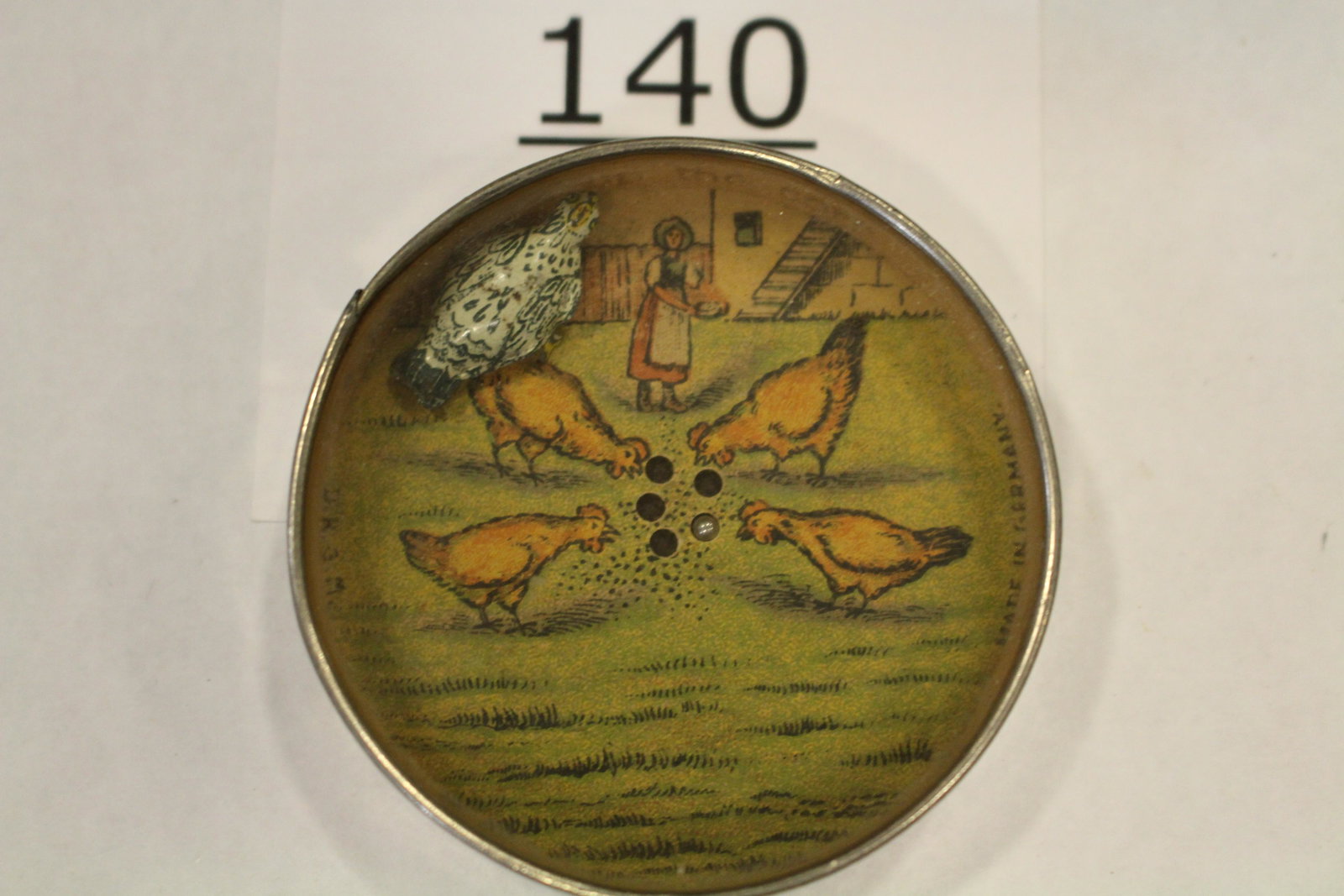 Full-Bodied Hen Eating Corn Dexterity Game: Dexterity game / handheld puzzle game full-bodied metal chicken / hen eating corn and fighting to keep it away for the other hens, "The hen picks up the corn" and "Made in Germany" text inside the rim