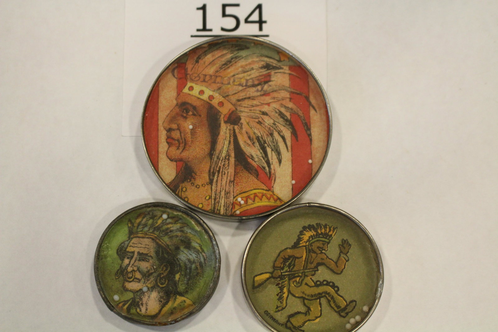 Lot of 3 Indian Chief Dexterity Games: Lot of 3 Indian-themed dexterity games / handheld puzzle games with image of Indian Chiefs: 1) wearing full headdress, stamped "Germany", metal frame, mirrored back, 2 1/4" W; 2) Indian in full headdr