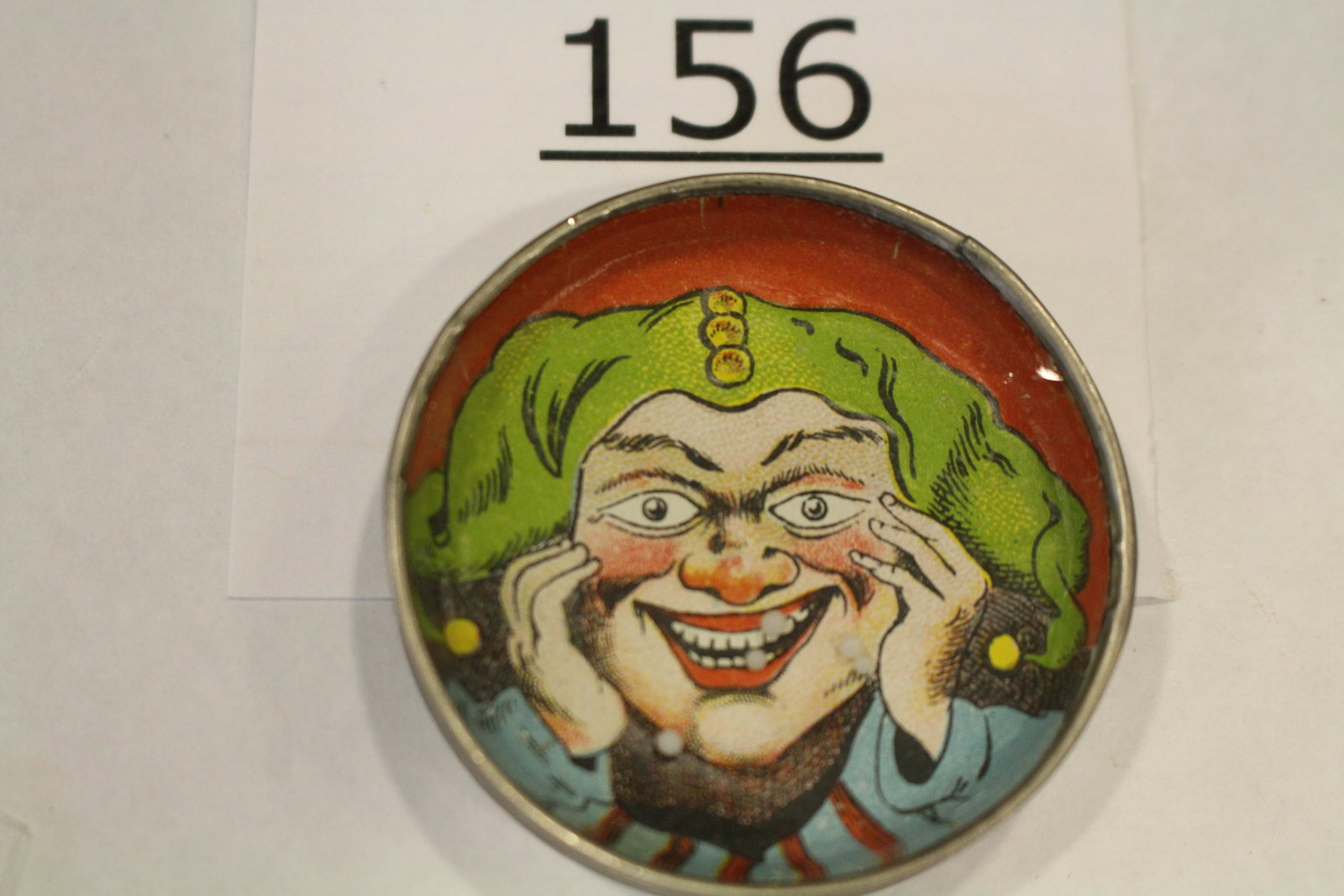 Court Jester Dexterity Game: Dexterity game / handheld puzzle game with image of a court jester, metal frame, cardboard back, 1 3/4" W. Good.