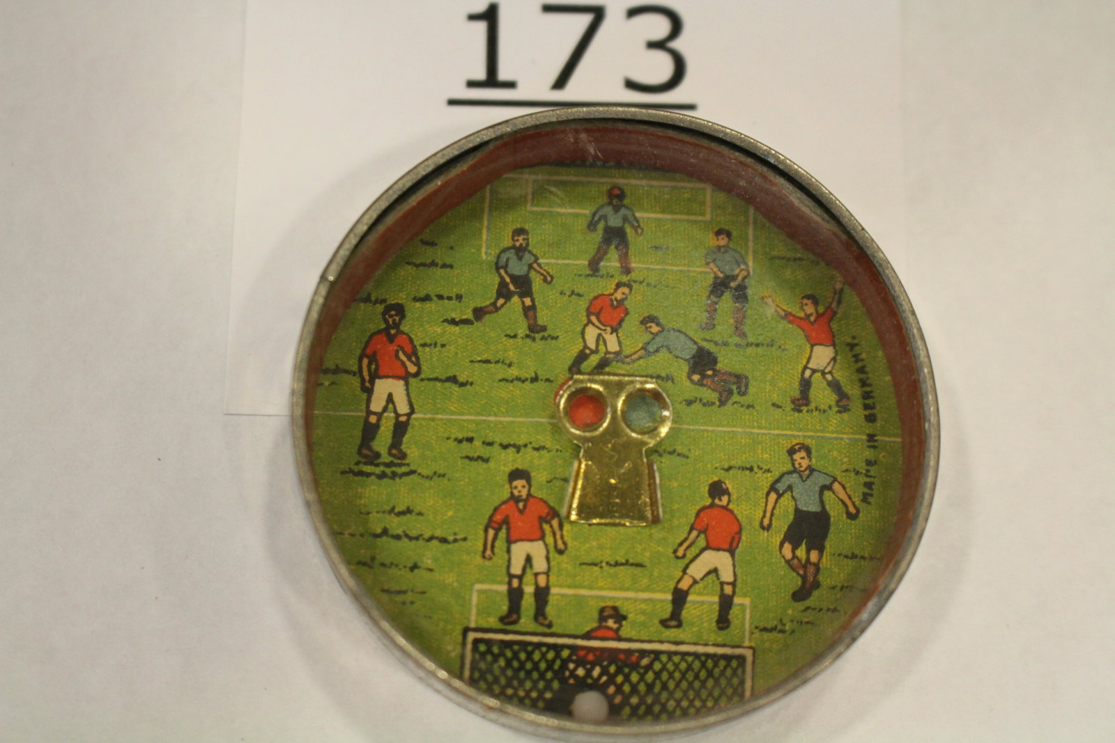 Teams Playing Soccer Dexterity Game: Sports-related dexterity game / handheld puzzle game with image of two soccer teams, challenge is getting the ball into the ramp / goal, 2" W, metal frame mirrored back, 2" W. Mirror slightly discolor