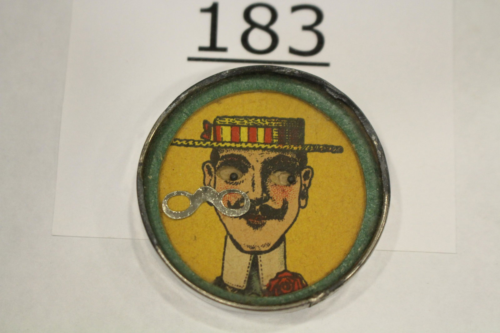 Man in Boater Hat Dexterity Game: Dexterity game / handheld puzzle game with image of a man in striped boater hat, rolling eyes, challenge is to get his metal glasses in place, cardboard back, 1 1/2" W. Good.
