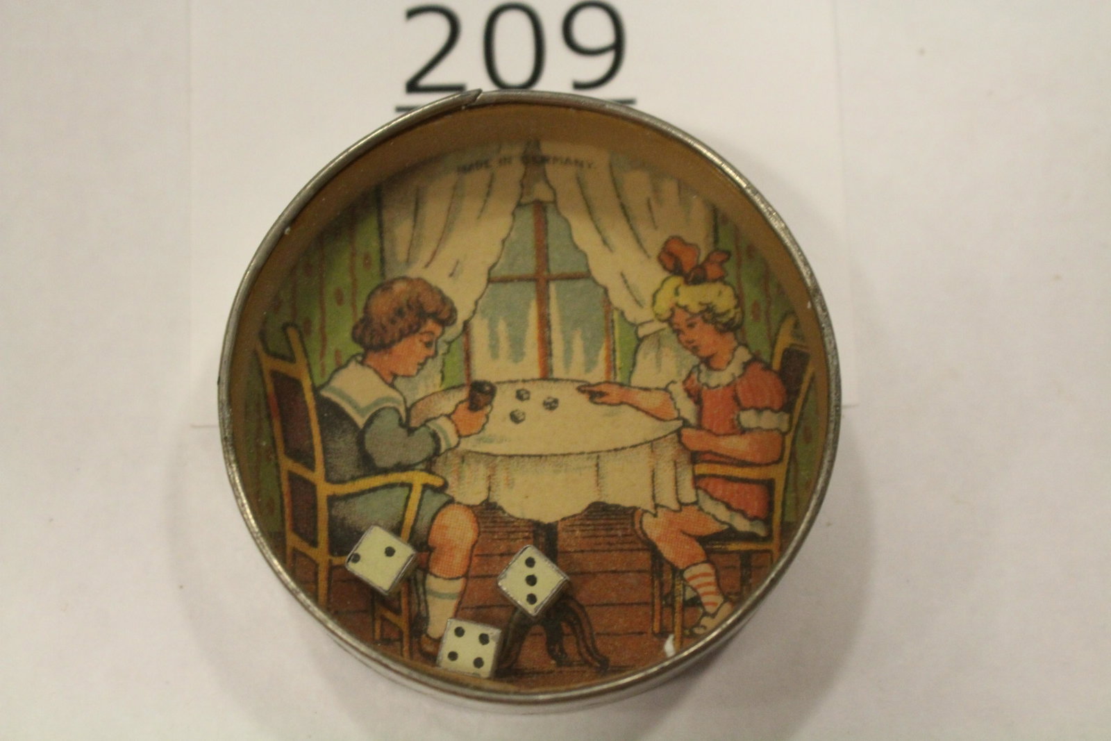 Boy & Girl Playing a Game of Dice Dexterity Game: Dexterity game / handheld puzzle game with image of a boy and girl playing dice, 3 dice, metal frame, mirrored back, 2 1/2" W. Discolored mirror.