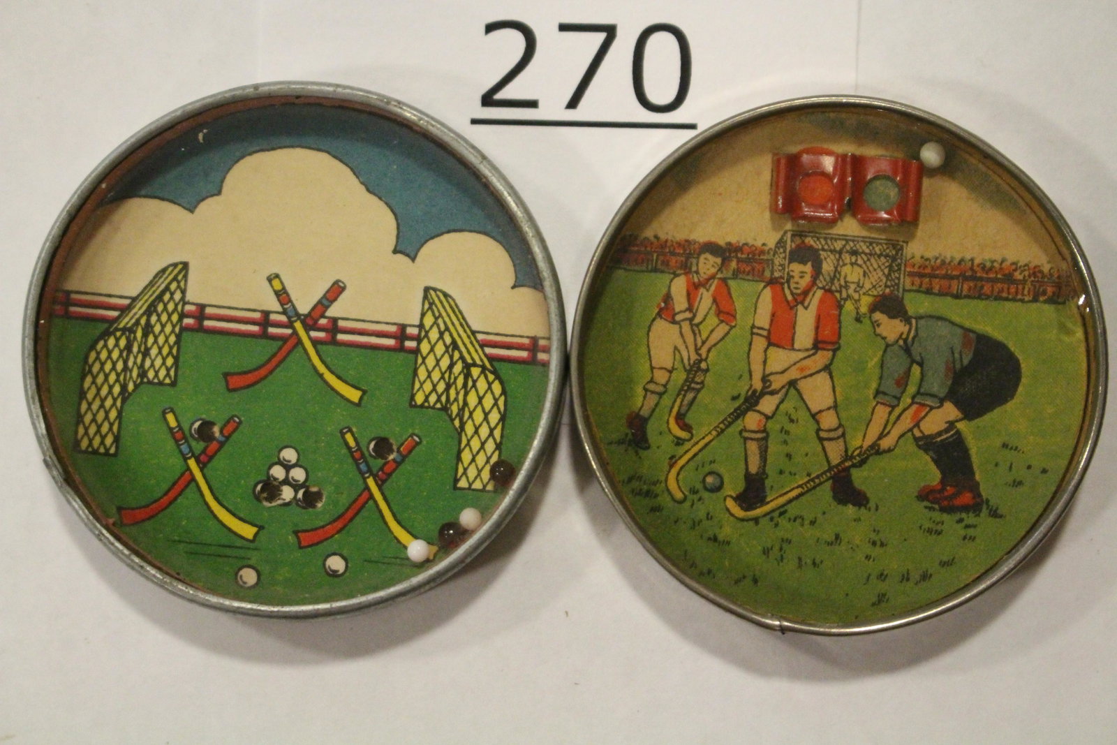 Sports-Themed Field Hockey Dexterity Games: Lot of 2 sports-themed dexterity games / handheld puzzle games with images of field hockey, both with metal frames, mirrored backs, one with metal goals, 2 1/4" W. Good.