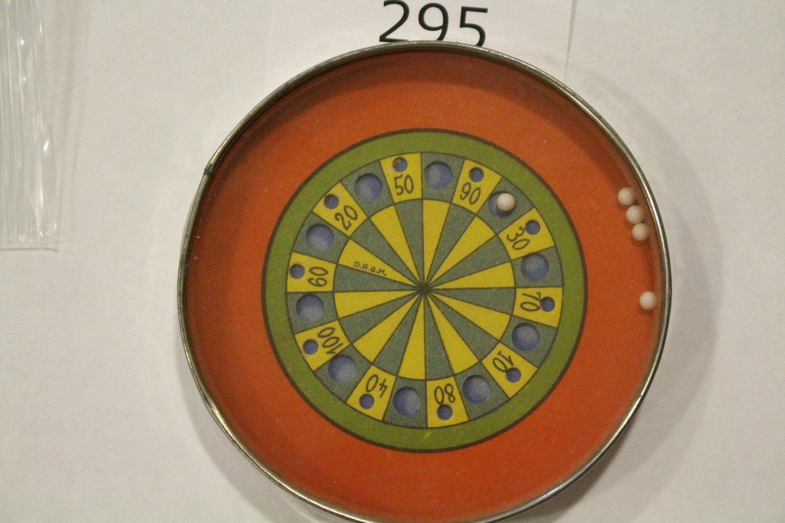 Gaming Roulette Wheel 4" W Dexterity Game: Dexterity game / handheld puzzle game with image of a roulette wheel with red background, metal frame, mirrored back, 4" W. Good.