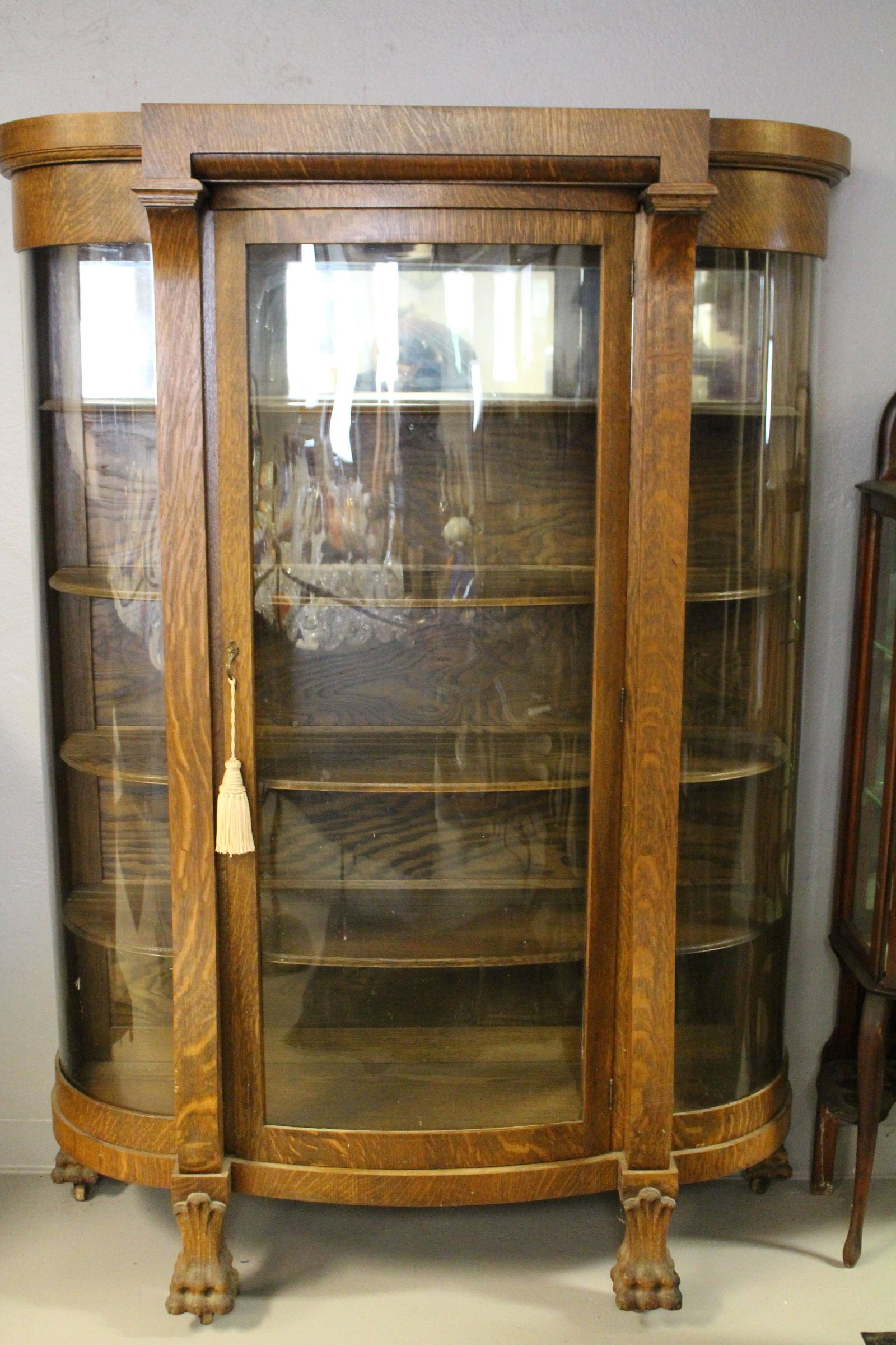Large Oak Curved Glass China Cabinet: Large Oak Curved Glass China Cabinet - massive claw feet, curved glass in door and sides, interior all original oak beveled-edged shelves, 71" H x 48" W x 16" D. No issues noted.