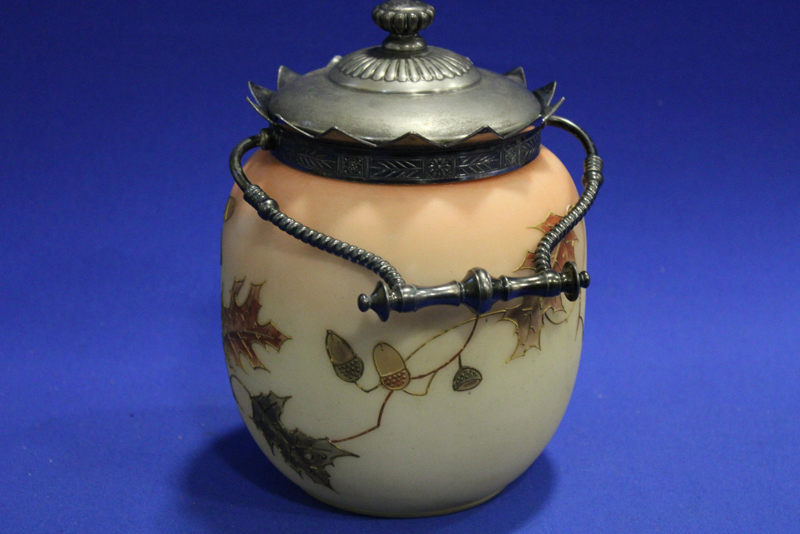 Mt. Washington Burmese Cracker Jar w/ Acorns: 1890s Mt. Washington Cracker Jar w/ Acorns - Burmese with gold gilt decoration, Pairpoint mark under lid, 6" H plus swing handle.