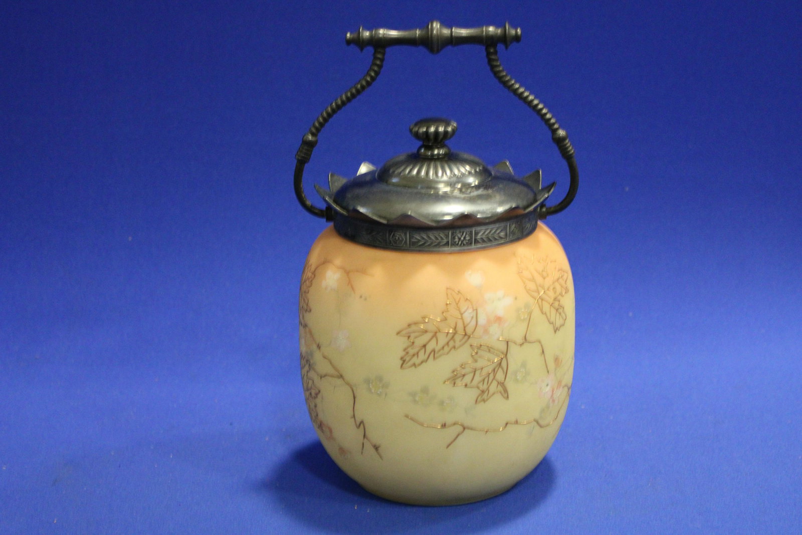 Mt. Washington Burmese Cracker Jar w/ Leaves: 1890s Mt. Washington Cracker Jar w/ Leaves - Burmese with gold gilt decoration, unmarked Pairpoint lid, 6" H plus swing handle.