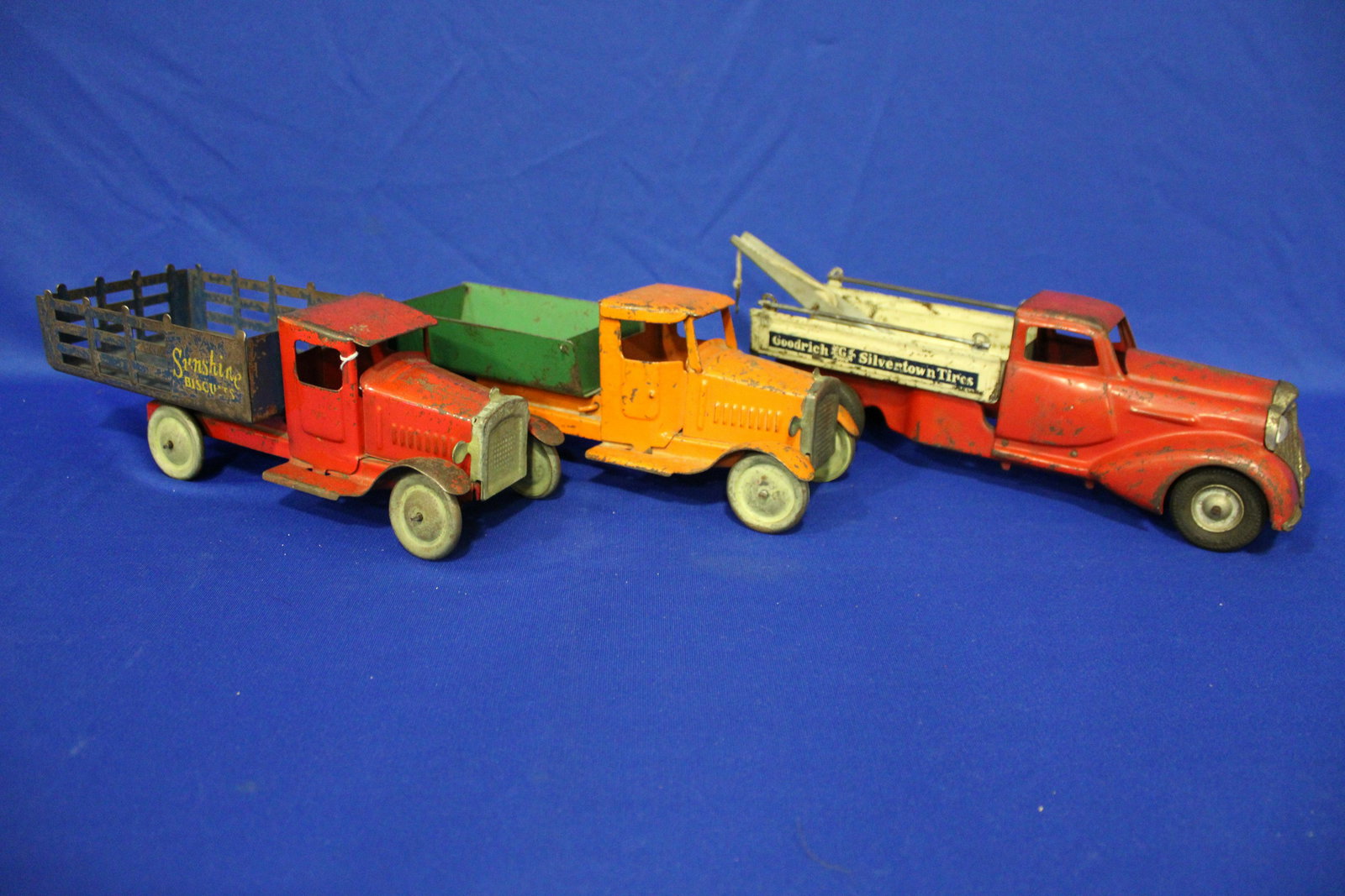 1930s Pressed Steel Delivery Trucks: 1930s Pressed Steel Delivery Trucks - 1) Metalcraft Sunshine Biscuits stake truck, 12'' L ; 2) unmarked dump truck, 11''; 3) Goodrich Silvertown Tires tow truck, 13 2/4'' L.
