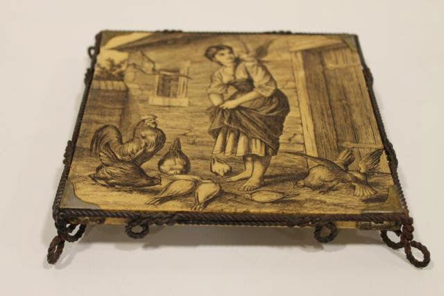 1800s Mintons Porcelain Trivet: Porcelain glazed tile trivet with image of maiden feeding chickens, signed Mintons China Works, twisted wire frame, 6 1/2" wide.