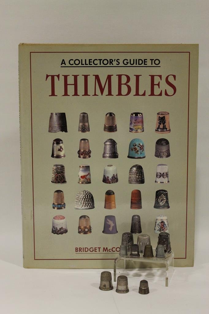 Group of Thimbles: 5 No. 1s, includes sterling, one with attached thread cutter; includes hard cover Bridget McConnel thimbles guide.