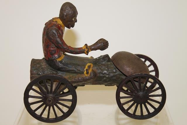 Cast Iron Mechanical Monkey Bell Pull Toy: Early 1900s Hill Brass Co. polychrome painted mechanical bell pull toy - monkey on wheeled log fitted with bell raises & lowers arm striking log with coconut causing bell to ring,