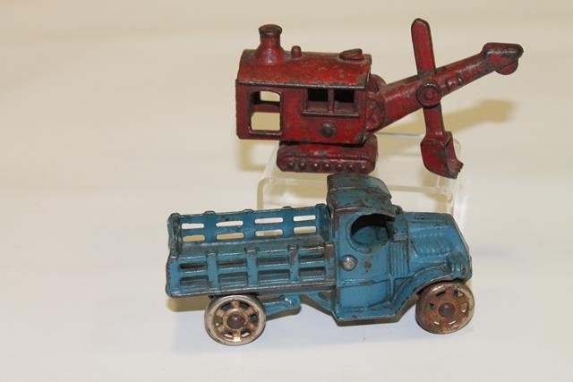 Hubley Steam Shovel & Mack Stake Truck: Cast iron Hubley steam shovel toy, original red paint, stamped on shovel "1562", 2 1/2" H; cast iron original blue paint farm truck with stake sides, unmarked Mack, 5" L.