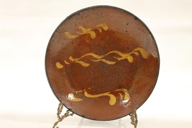 Redware Pennsylvania Pie Plate: Early 1800s redware pie plate, coggle edging, Pennsylvania, 3 rows yellow slip ware squiggles, center having largest, shiny, clear lead-glazed surface, 9 3/4" W.