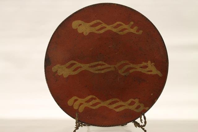 Redware Pennsylvania Large Pie Plate: Early 1800s redware pie plate, coggle edging, Pennsylvania, interior with three wavy rows of yellow slip decoration, shiny, clear lead-glazed surface, 12" W x 2 1/4" H.