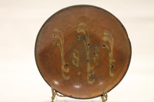 10 1/4 Pennsylvania Redware Pie Plate: 10 1/4" across pie plate, coggle edging, Pennsylvania, interior with 3 curvy bands and two smaller bands of yellow slip decoration, lead-glazed surface.