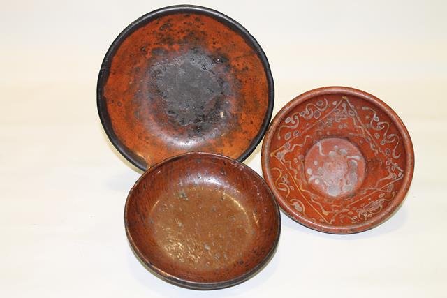 3 Early 19th C. Redware Bowls: Three early 19th century slip decorated redware bowls: bowl with squiggle decoration, 2 3/4" H; shallow bowls / plates - spatter paint decorated smallest, 7" across; and largest with black rim, 9" acr