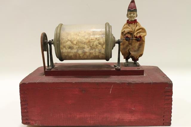 1900s Popcorn Vendor's Automaton Clown: Early 1900s popcorn vendor's automaton clown with glass cylinder - clown "pumped up and down" turning the popcorn machine's motor keeping popcorn from burning, clown with original cloth costume, bisqu