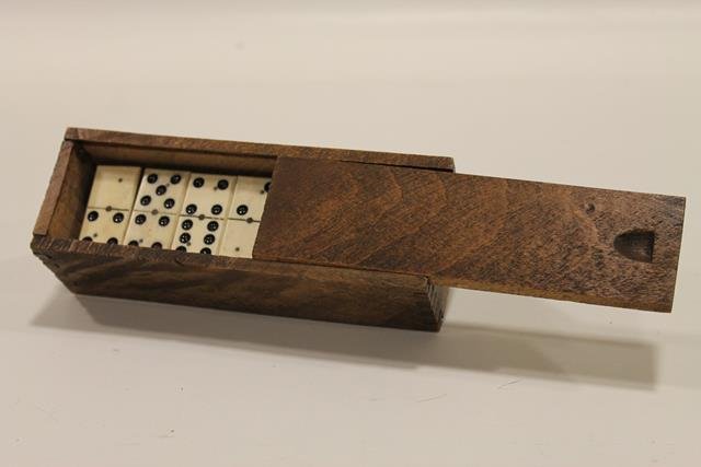 Early 1900s Ebony & Ivory Dominoes: Wooden, slide lid, box, 28 dominoes in box. Question received from internet regarding actually ivory or bone??? We relied on estate note that said it was ivory.