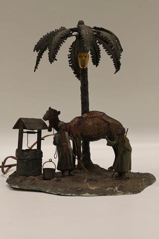 Austria Cold-Painted Oasis Scene Lamp: Austria cold painted white metal lamp in the form of an oasis with a palm tree, a camel, a well, and two Arab men, 13" H.