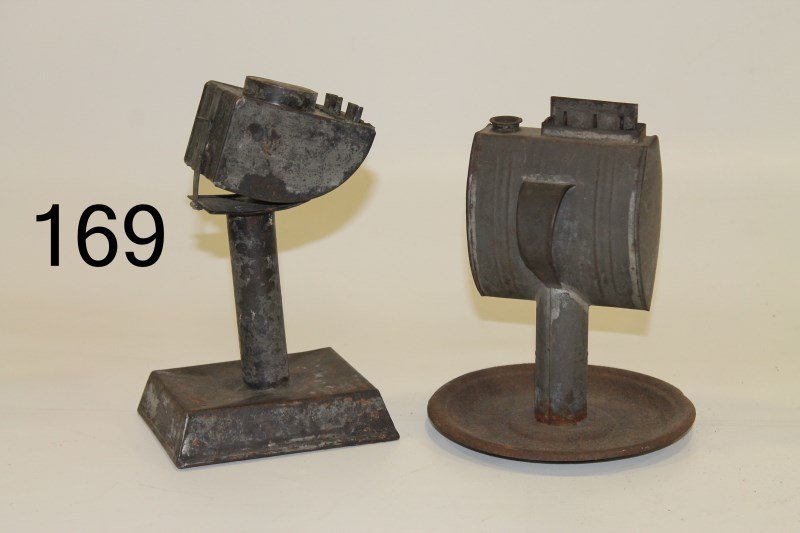 Two Tin Lard Lamps: One with handle, 7 1/4" H; tilt font lamp on pedestal, 4 1/4" H.