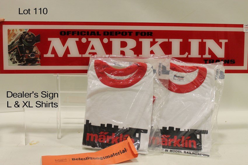 Marklin HO Dealer's Sign & T-Shirts: Dealer sign in original packaging, chain, hangs on wall or tabletop easel; t-shirts factory sealed unopened size L & EX L