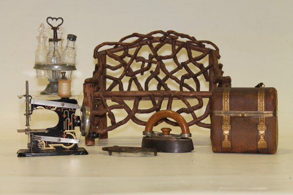 Grouping Doll-Related Items - Twig Bench, Castor Set,: Child's doll size - Twig bench, 11" w; 4-bottle castor set in SP frame; sad iron and trivet; tin decorated sewing machine, leather covered hard form purse; The upper darker portion of the castor's han