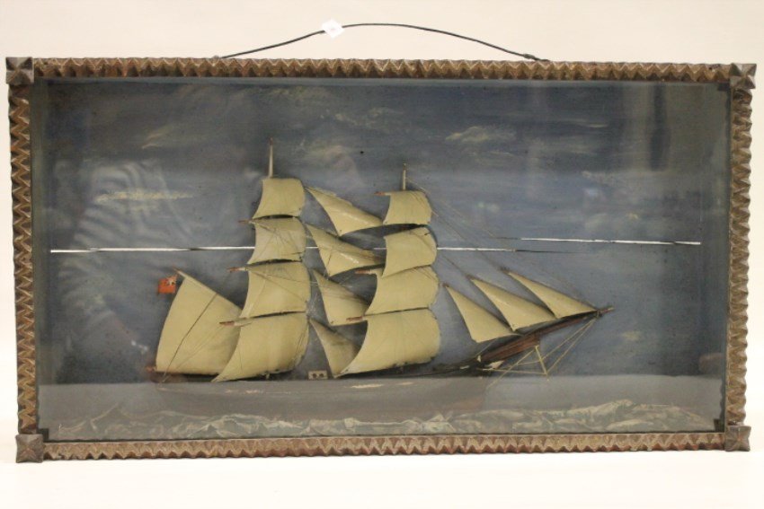 Diorama of English Sailboat / Schooner: Very early wooden diorama of an English schooner / sailboat on molded waves, background with painted sky and clouds, flying British flag, original wooden case measures 28" W x 15" H x 4 1/2" D.