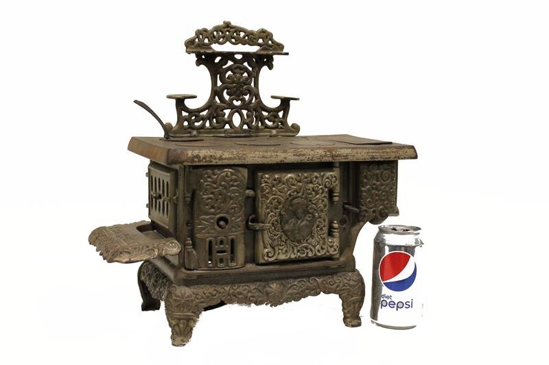 Cast Iron Toy Stove - The Queen: Early 1900s Dent Hardware Co, The Queen, salesman sample / toy, large stove, nickel plated, 6 burner and reservoir, elaborately embossed, 3 swing doors, rear access panel, 16" W x 15" H.
