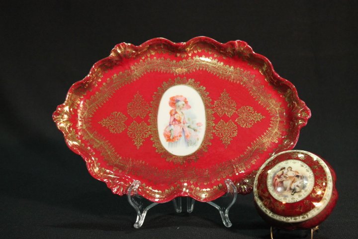 UM Prussia Red Portrait Tray and Dresser Box: Unmarked - red with heavy gold highlights tray with center portrait of lady in garden, 12" L; similar but not matching round dresser jar with scenic portrait.