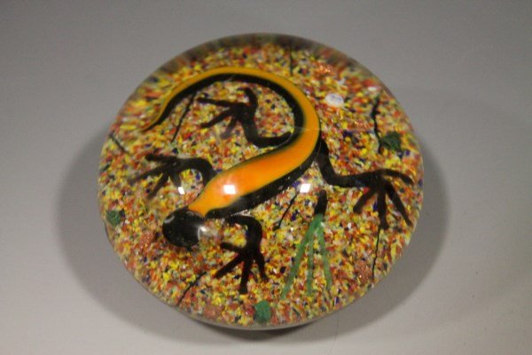 John Choko Art Glass Paperweight - Salamander: Signed "JC" John Choko art glass paperweight depicting black and orange salamander sitting on bed of multicolored sand, 2" H. Cholo born in Millville in 1935, died 1991. In 1991, Gay Taylor, Curator,