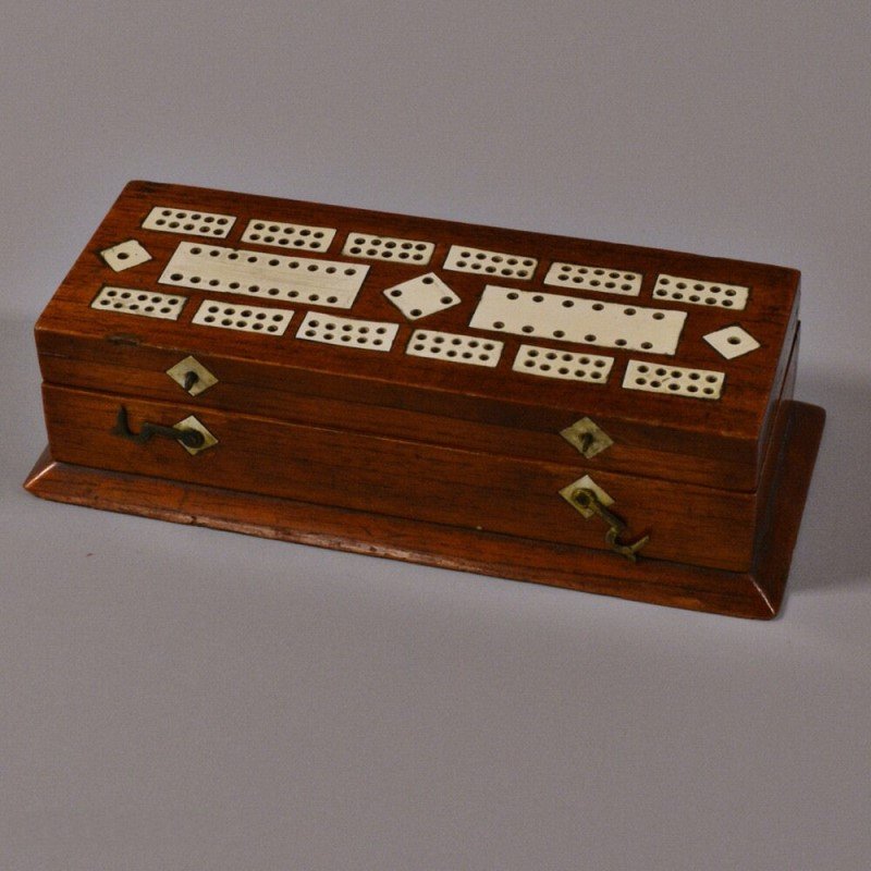 Cribbage and Playing Card Game Box - Inlaid Bone: 19th century game box, cribbage playing field with bone inlay lifts to reveal a compartmented interior with colored game pieces, playing cards, and a card suit marker, all on a projecting molding, 9 3