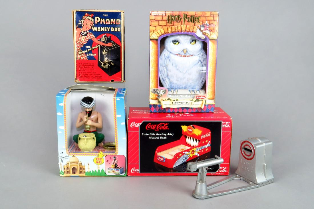 Lot of 5 Plastic and Metal Recent Mechanical Banks: 5 Recent Mech. Banks, Plastic and Metal: "Phono Money Box"; "Snake Charmer"; "Atomic Bank", missing trap, no box; "Coca Cola Bowling Bank"; "Hedwig Bank"