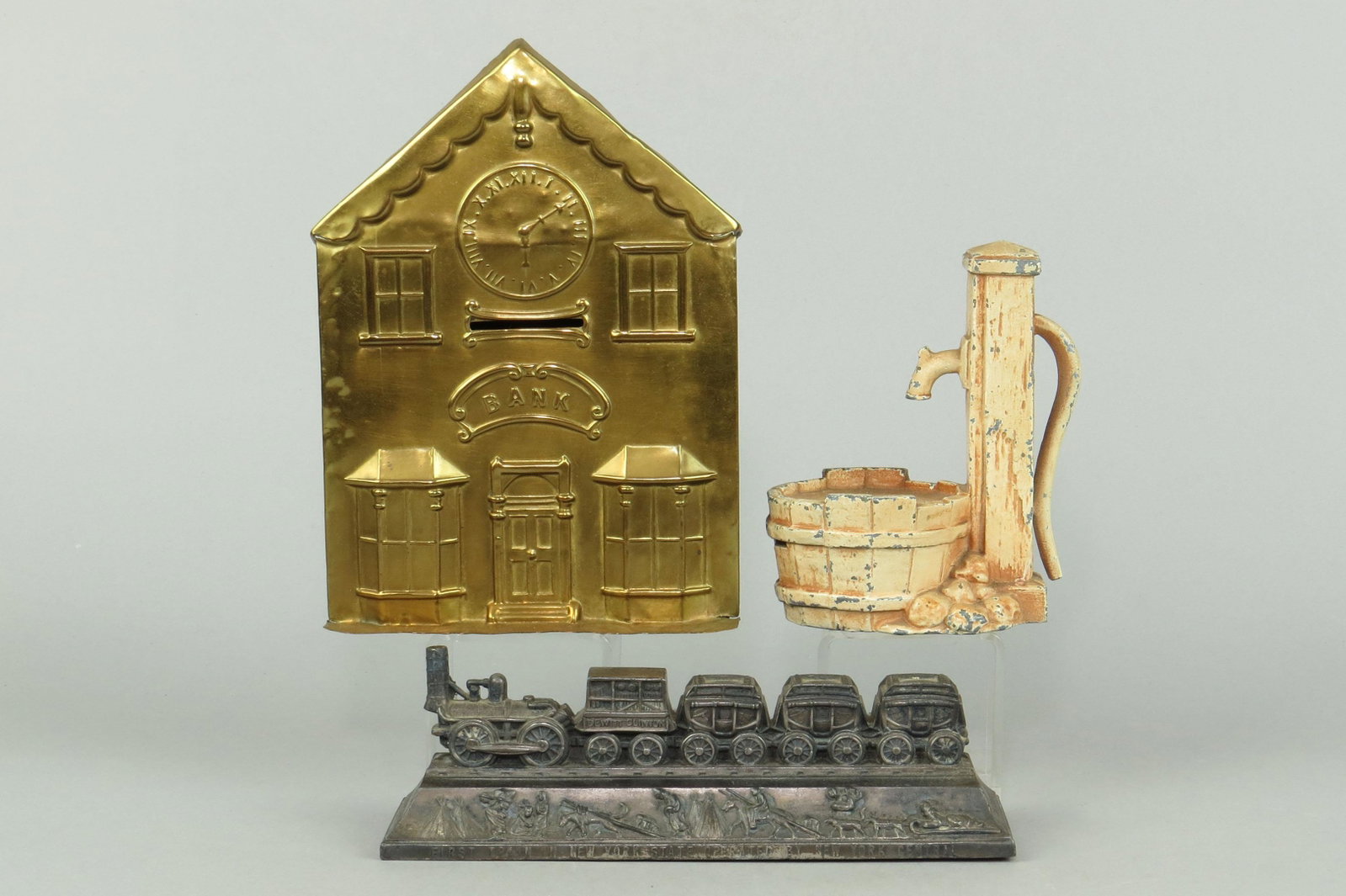 Lot of 3 Tin/Lead/PM Misc. Banks: 3 Misc. Banks, Tin/Lead/PM: Birth Bank w/Stamped Clock, M N/L, 7"; "Dewitt Clinton Railroad w/key, M1477, 2 1/8"; Pump and Bucket Bank, M1253, 4 1/2"