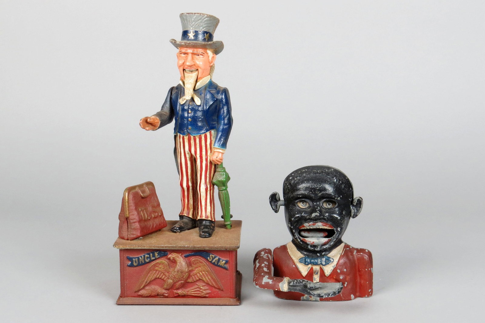 Lot of 2 CI/Alum Mechanical Banks: 2 Mech. Banks, CI/Alum: Repro Uncle Sam w/Spring loaded coin trap; Unmarked Jolly, alum.