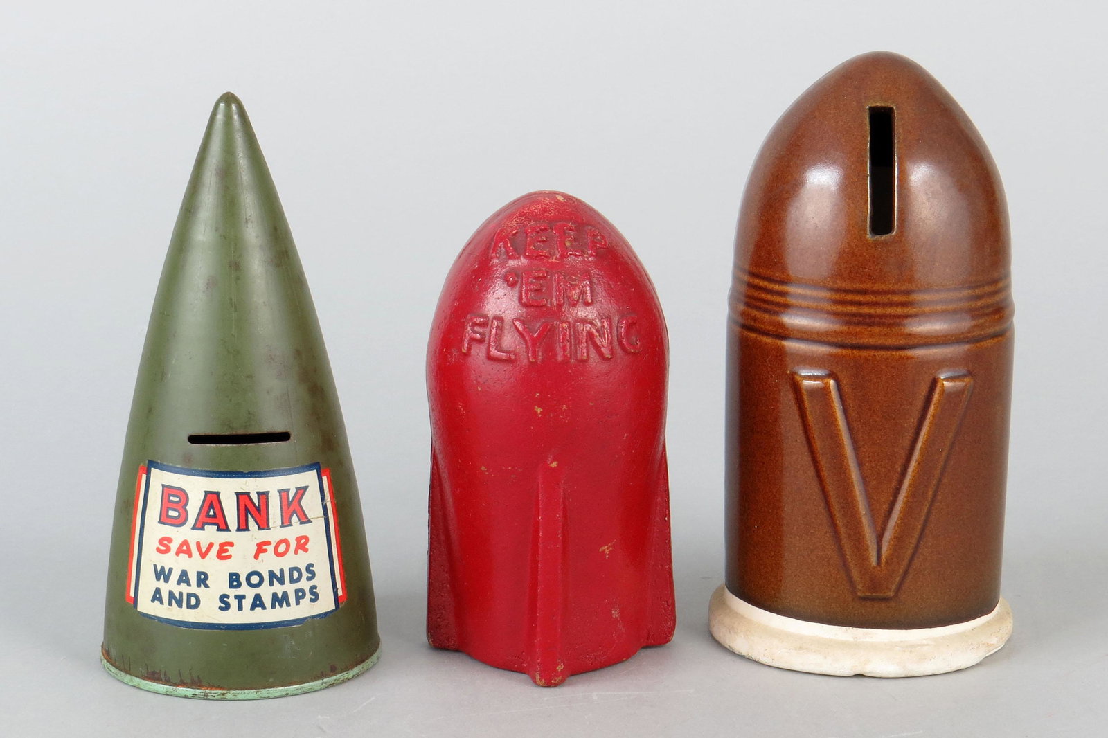Lot of 3 Tin/Pressed Cdbd/Ceramic World War Bomb Banks: 3 World War Bond Banks, Tin/Pressed Cdbd/Ceramic: "Save for War Bonds and Stamp"; "Keep 'em Flying"; "V"