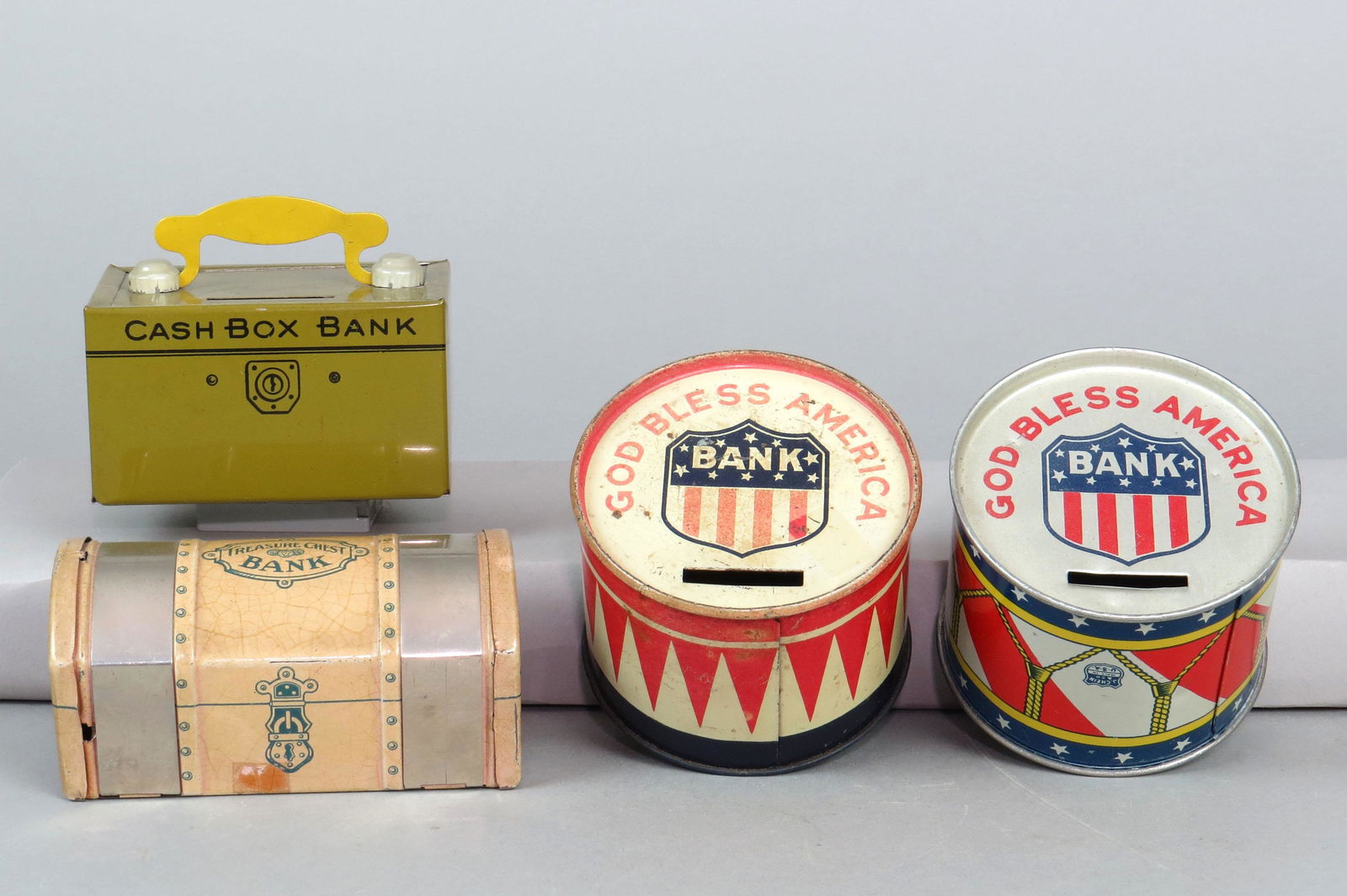 Lot of 4 Tin Chein Banks: 4 Chein Banks, Tin: (2) different "God Bless America" Drums; "Cash Box Bank"; "Treasure Chest Bank"