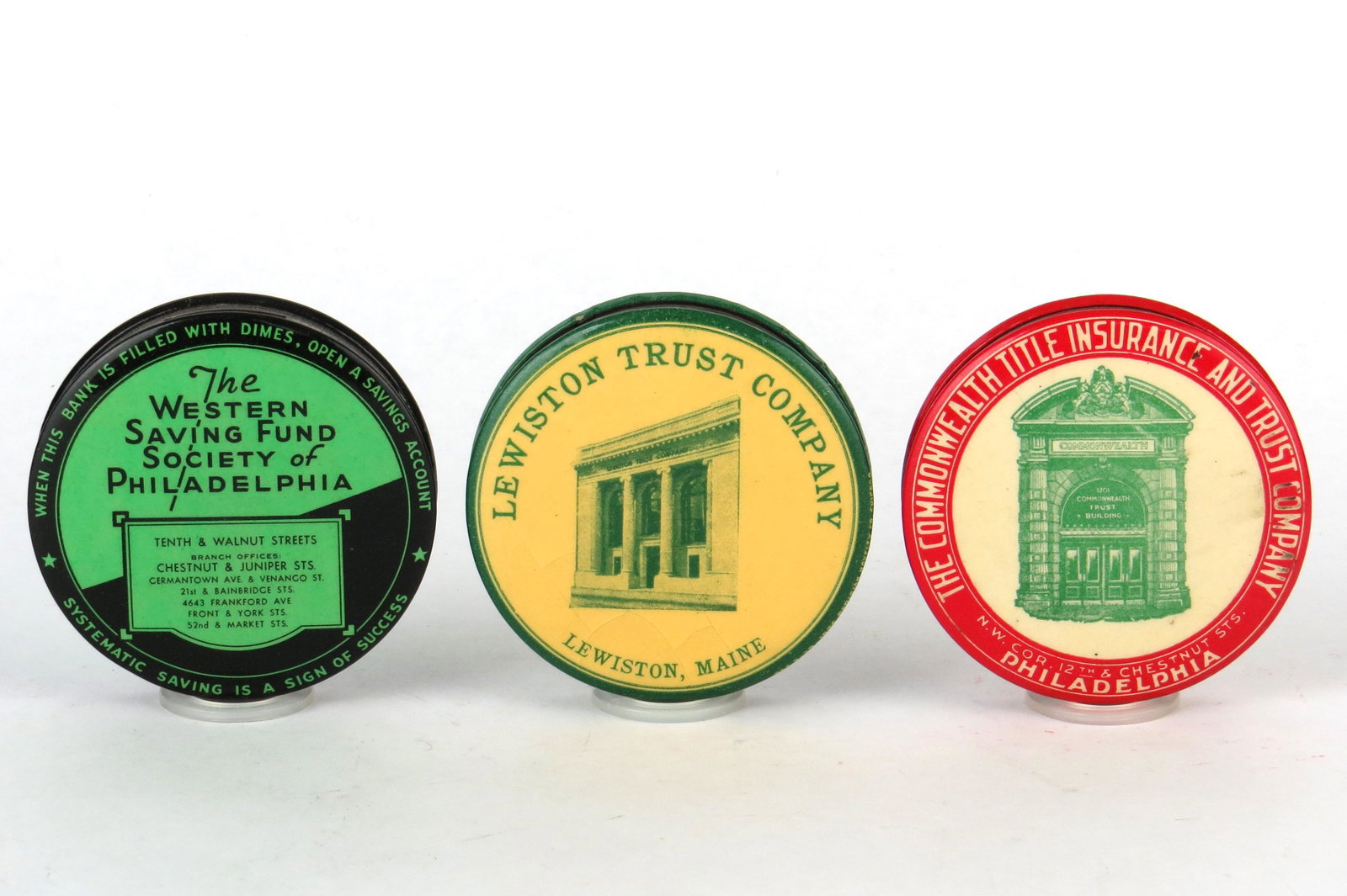 Lot of 3 Round Pocket Banks: 3 Round Pocket Banks, Celluloid: "The Western Saving Fund Society of Philadelphia"; "Lewiston Trust Company, Lewiston, Maine", Some cracking; "The Commonwealth Title Insurance and Trust Company, Phila