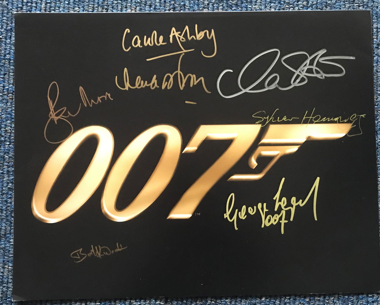 James Bond multiple signed 16 x 12 inch colour photo: James Bond multiple signed 16 x 12 inch colour photo. Signed by seven actors inc Roger Moore, George Lazenby, Lana Wood, Burt Kwouk, Carole Ashby, Sylvana Henriques. Condition 9/10. All autographs com