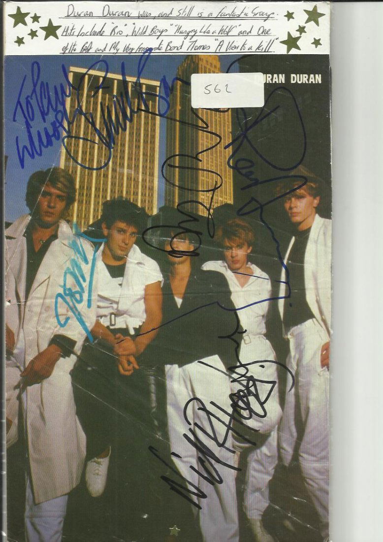 Duran Duran colour magazine photo mounted on card: LOT107 - Duran Duran colour magazine photo mounted on card signed by all five band members Simon Le Bon, Nick Rhodes, John Taylor, Rodger Taylor & Andy Taylor. They sang View to a Kill. Scarce.