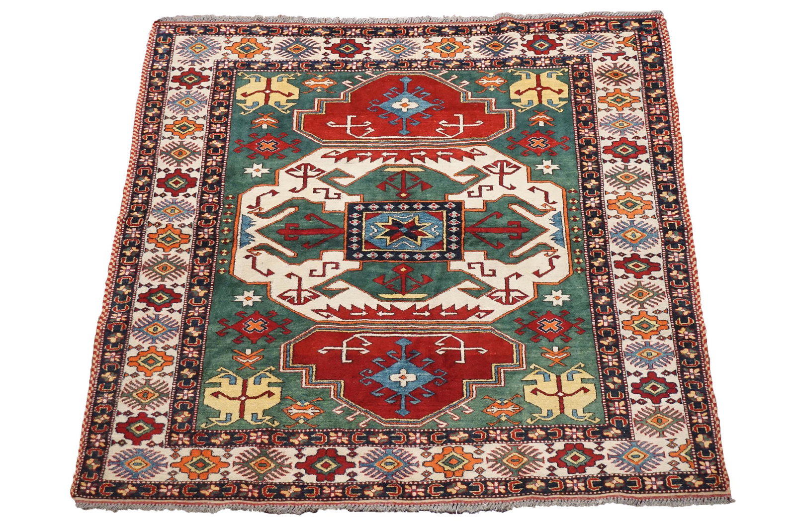 Fine 6X6 Pak Kazak Square Green Hand-Knotted Rug: Size: 6 x 6.2 Country of Origin: Pakistan Age: New Condition: Excellent Field Color: Hunter-Green Border Color: Beige Accent Color: Midnight-Blue, Cherry-Red, Gold, Orange, Light-Blue Technique: Hand-