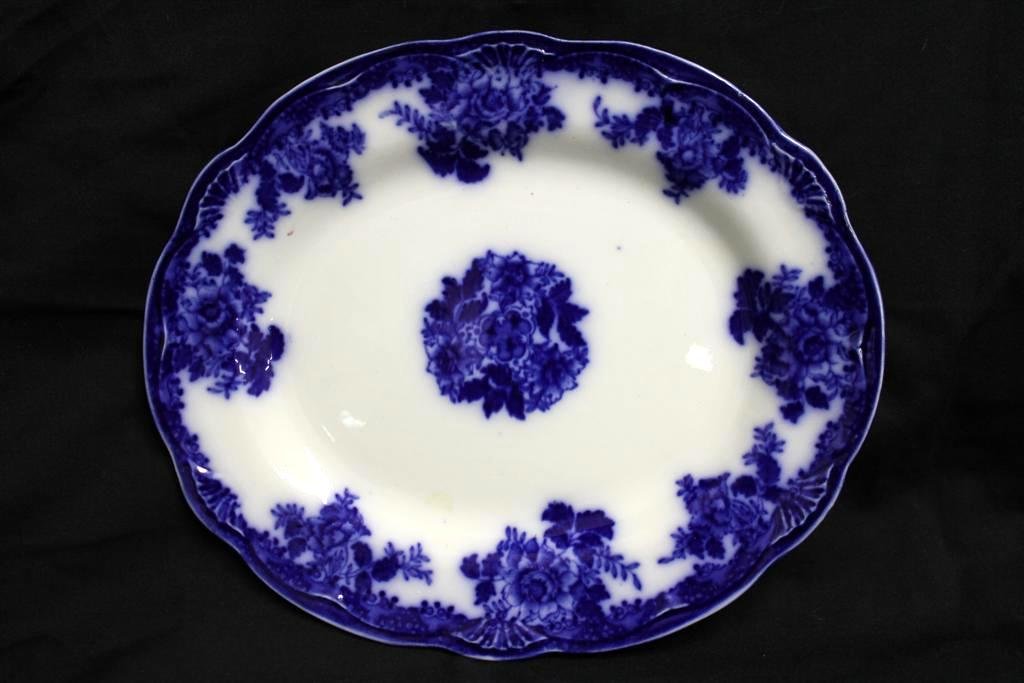1890's New Wharf Waldorf Flow Blue Platter: Beautiful Oval Platter or tray. Made in the late 1800's by the New Wharf company in Staffordshire UK. It is there floral Deep Flow Blue transferware pattern called Waldorf. The platter itself has a sc