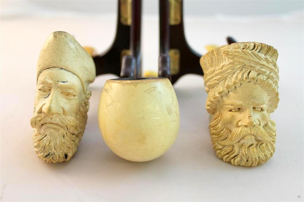 Antique Figural Head Face Meerschaum pipes: a group lot of three antique Meerschuam pipes. Two are hand carved with large detailed faces and heads on them. One a rround ball pattern. Measures approx. 3" by 3" by 1-1/2".