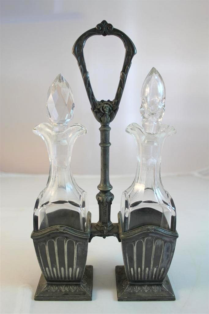 Antique Cruet Bottle Set in Silverplate Stand: A beautiful matched antique cruet set. Made of beautiful antique cut glass. Both come in the original stand. Which is a Victorian style silverplate holder with handle. Marked Minerva on the bottom. Me