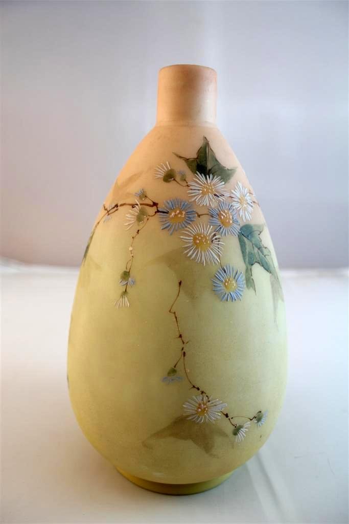 Mt. Washington Burmese Enameled Vase: A bulbous antique 19th Century Mt. Washington attributed glass vase. In Burmese shaded color with enameled decoration all around. Polished pontil. Measures 8-1/2” by 5”.