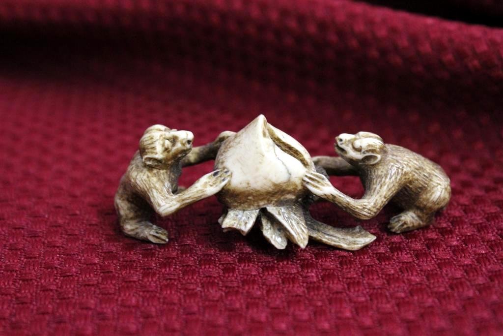 Chinese Ivory Carved Netsuke Monkeys with fruit or flow: fantastic antique hand carved solid ivory netsuke style figurines with two monkeys seated both holding a large fruit or flower of some sort. Measures 2-1/4” by 2”.