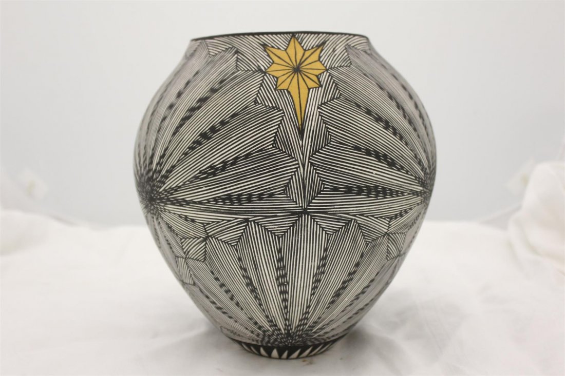 Large Acoma New Mexico Pottery Vessel D.E. Valio: Beautiful fine hand made & painted New Mexican Art Pottery Vessel. Signed D.E. Valio Acoma NM. Hand painted black & White lines in star form with gold painted stars in between. Approx 10” tall.
