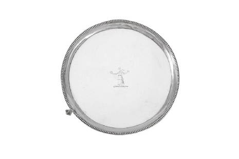 A George III sterling silver teapot stand or waiter,: A George III sterling silver teapot stand or waiter, London 1783 by Hester Bateman Of circular form with cavetto edge and beaded border, raised on three ball and claw feet. The field engraved with a c