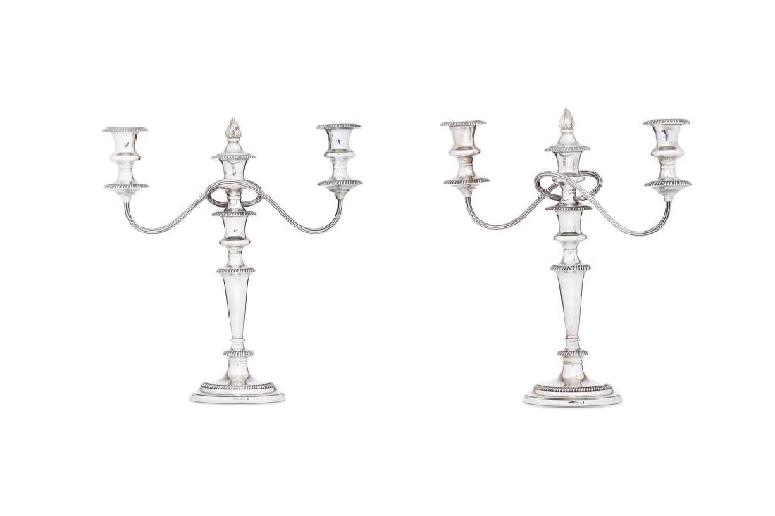 A pair of Elizabeth II sterling silver candelabra,: A pair of Elizabeth II sterling silver candelabra, Birmingham 1986 by Harrods Each in the Georgian taste, of stepped circular form with gadrooned borders. Each with removable twin arm branches, an