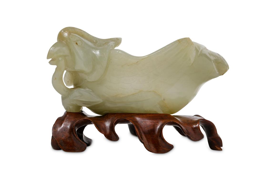 A CHINESE PALE CELADON JADE 'MANDARIN DUCK' WASHER.: A CHINESE PALE CELADON JADE 'MANDARIN DUCK' WASHER. 19th/20th Century. Carved as a bird with legs tucked underneath the body and a lotus flower stem in its beak, the body well hollowed, together with 